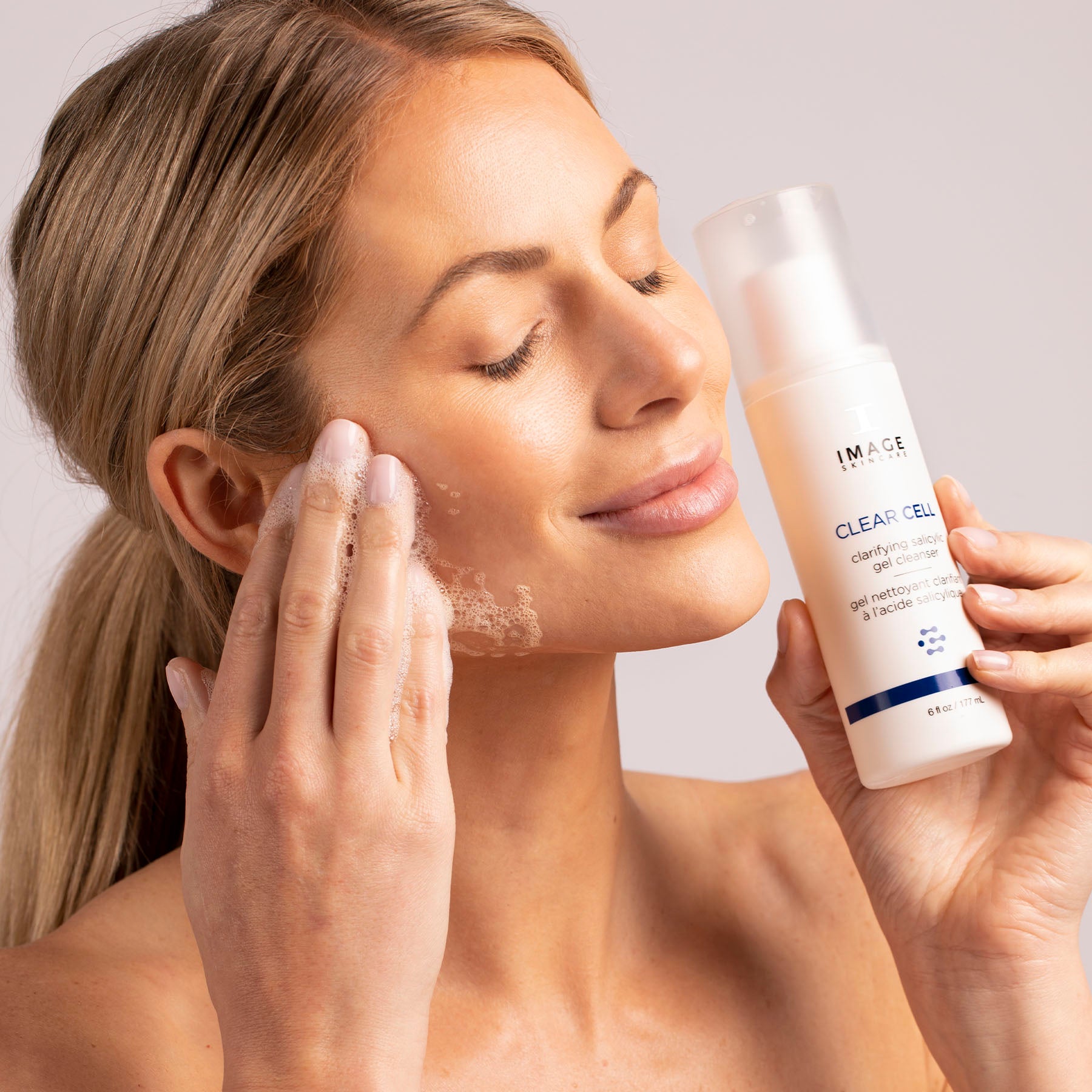 Woman using salicylic acid cleanser on her face