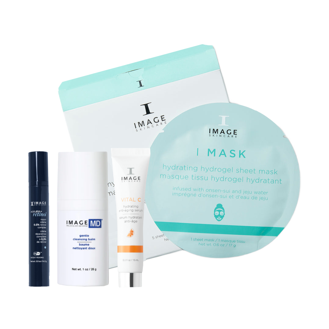 A skincare gift set from Image Skincare on a white background, featuring a large round sheet mask, a white and mint box, a white and orange tube, a white bottle, and a dark blue spray bottle.