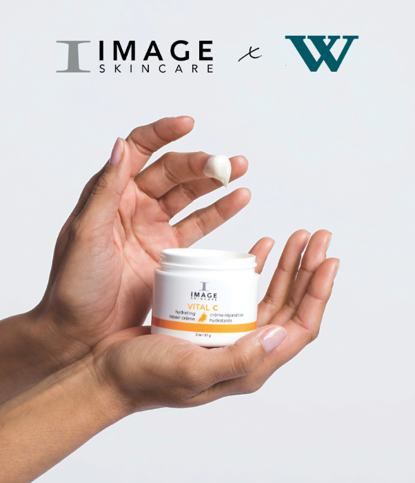 Hand holding a jar of Image Skincare product with visible branding on a light grey background
